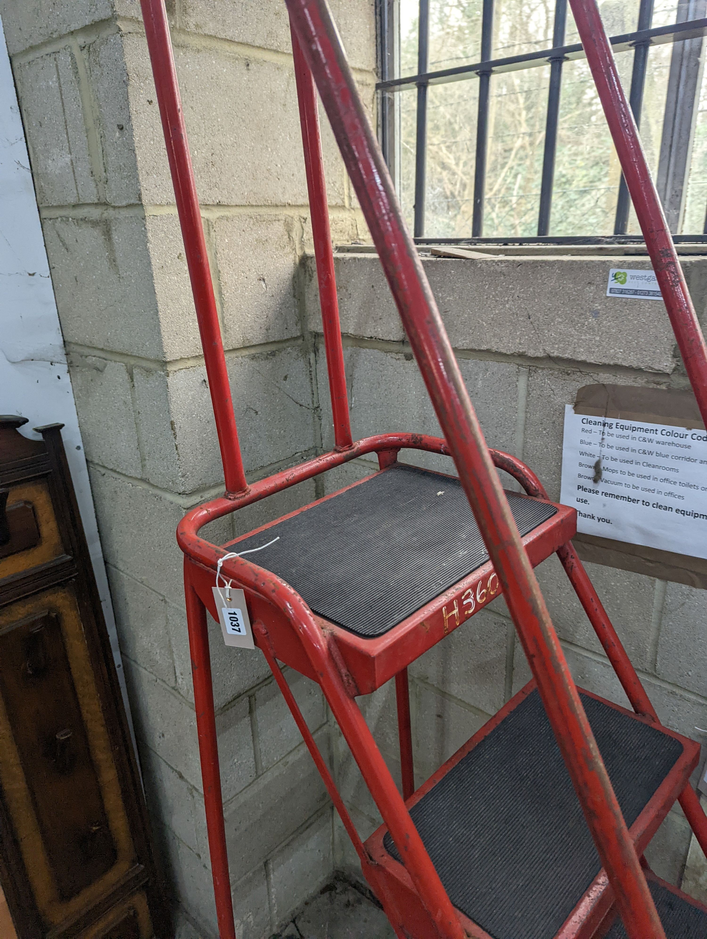 A set of red painted metal steps, height 188cm